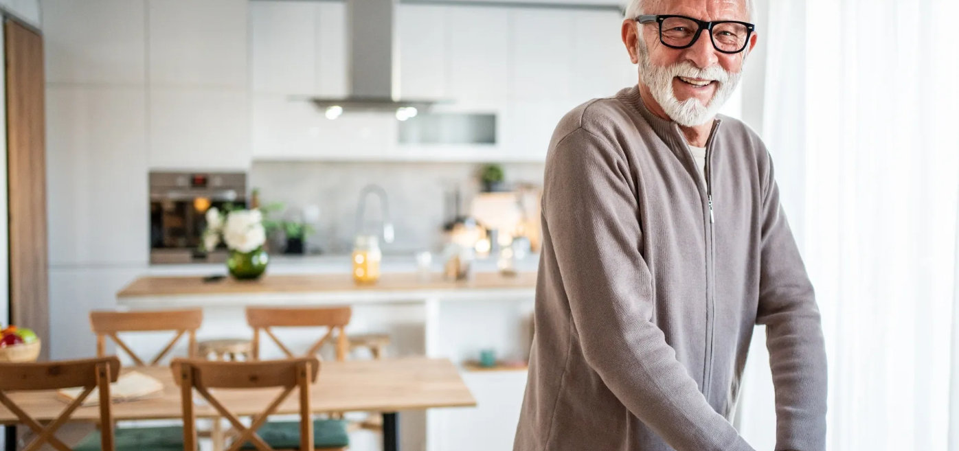 Senior man smiling in modern kitchen